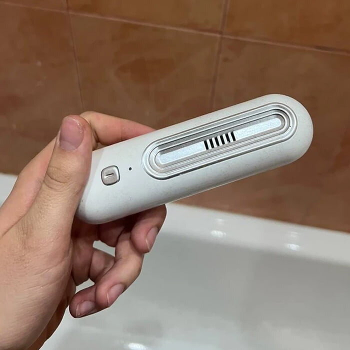 Ozoori deodorizer held in a bathroom